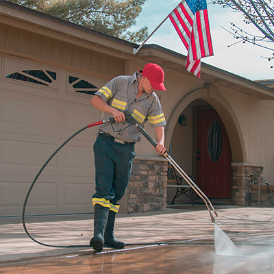 USA Washers technician pressure washing a driveway